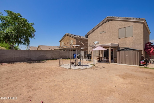 12517 W Santa Fe Ln, El Mirage, AZ 85335 - rear view of property with a fenced backyard, a storage shed, stucco siding, a patio area, and an outdoor structure