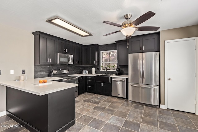 12517 W Santa Fe Ln, El Mirage, AZ 85335 - kitchen featuring light countertops, a peninsula, tasteful backsplash, appliances with stainless steel finishes, and ceiling fan
