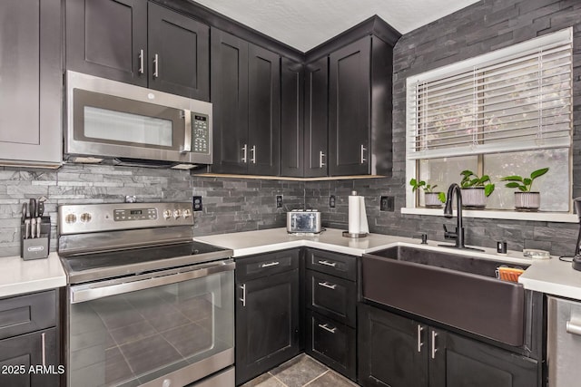 12517 W Santa Fe Ln, El Mirage, AZ 85335 - kitchen with backsplash, appliances with stainless steel finishes, a sink, and light countertops