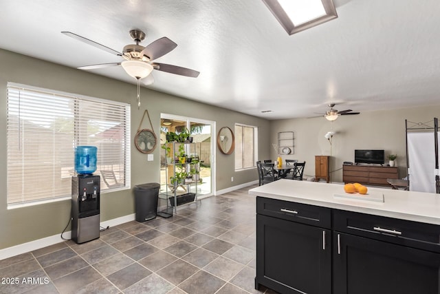 12517 W Santa Fe Ln, El Mirage, AZ 85335 - kitchen featuring ceiling fan, baseboards, dark cabinets, and light countertops