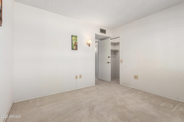 19402 N Welk Dr, Sun City, AZ 85373 - unfurnished bedroom featuring baseboards, a spacious closet, a textured ceiling, carpet floors, and visible vents