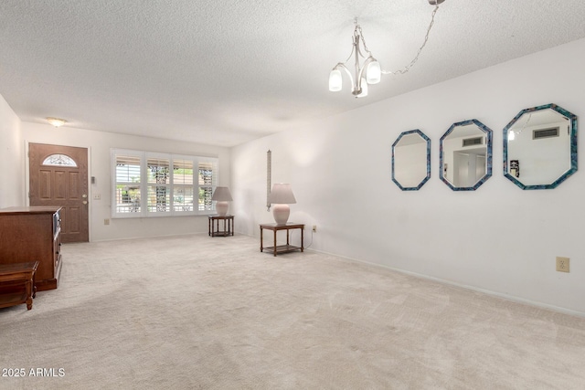 19402 N Welk Dr, Sun City, AZ 85373 - unfurnished room featuring a textured ceiling, a notable chandelier, and carpet