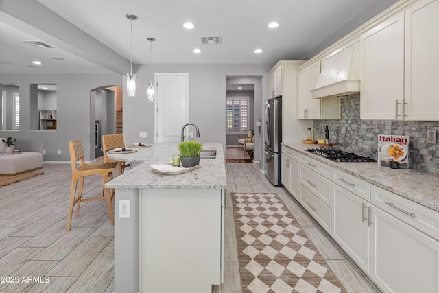 3603 E Salter Dr, Phoenix, AZ 85050 - kitchen featuring a sink, stainless steel appliances, custom range hood, visible vents, and backsplash