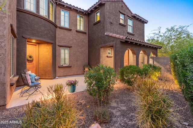 3603 E Salter Dr, Phoenix, AZ 85050 - view of side of home with a patio, stucco siding, and a tiled roof