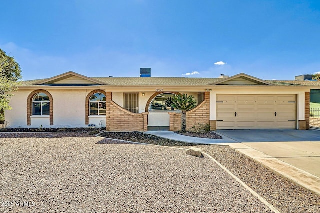 ranch-style house with brick siding, a garage, driveway, and stucco siding