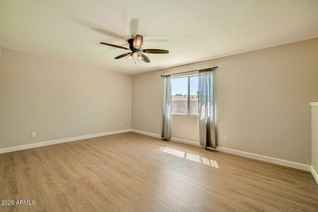 empty room featuring light wood-style flooring, baseboards, and ceiling fan