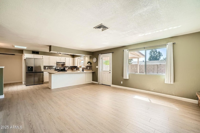 kitchen featuring white cabinets, visible vents, stainless steel refrigerator with ice dispenser, and light wood finished floors