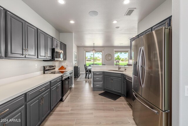 kitchen featuring stainless steel appliances, sink, and light hardwood / wood-style floors