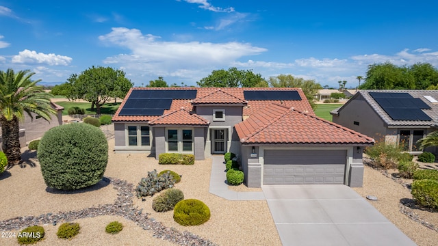 mediterranean / spanish-style house with a garage and solar panels