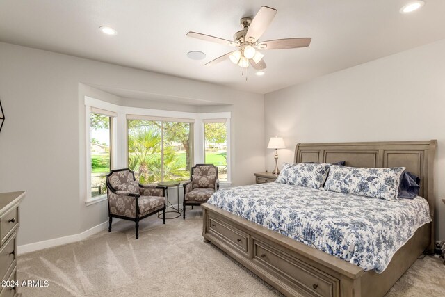 carpeted bedroom featuring multiple windows and ceiling fan