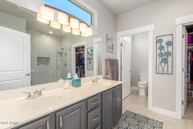 bathroom with tile patterned flooring, vanity, toilet, and walk in shower