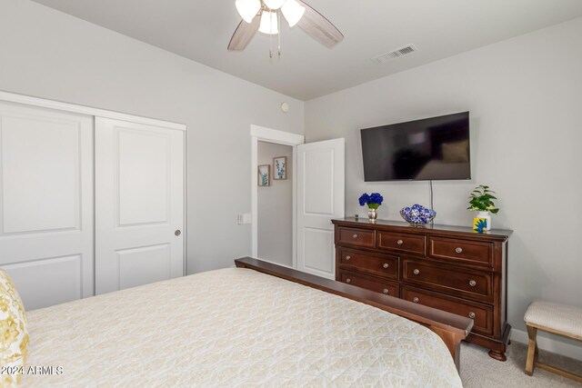 carpeted bedroom with ceiling fan and a closet