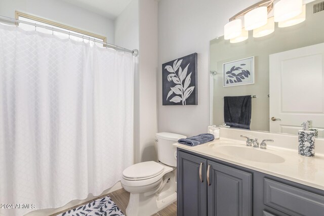 bathroom featuring vanity, toilet, and a shower with curtain