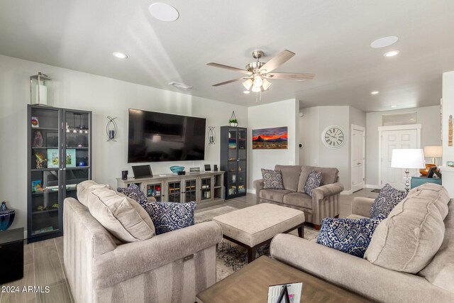 living room featuring light hardwood / wood-style flooring and ceiling fan