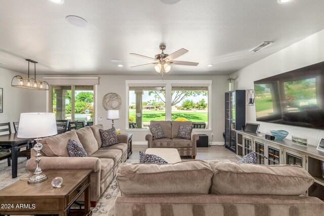 living room featuring a wealth of natural light and ceiling fan