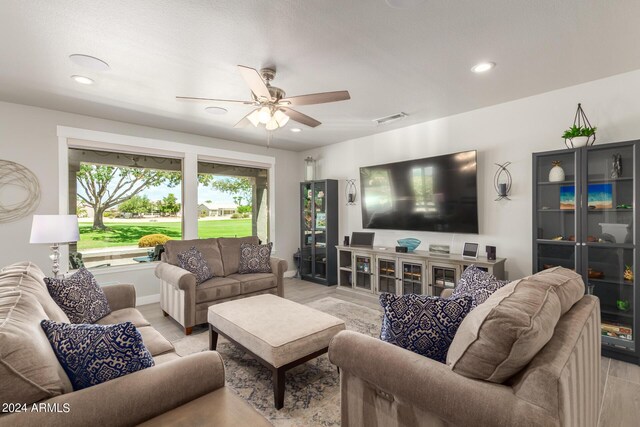 living room with ceiling fan and light hardwood / wood-style flooring