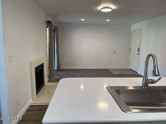 kitchen with hardwood / wood-style floors and a brick fireplace