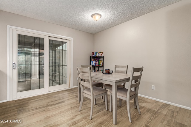 dining room featuring a textured ceiling and light hardwood / wood-style flooring