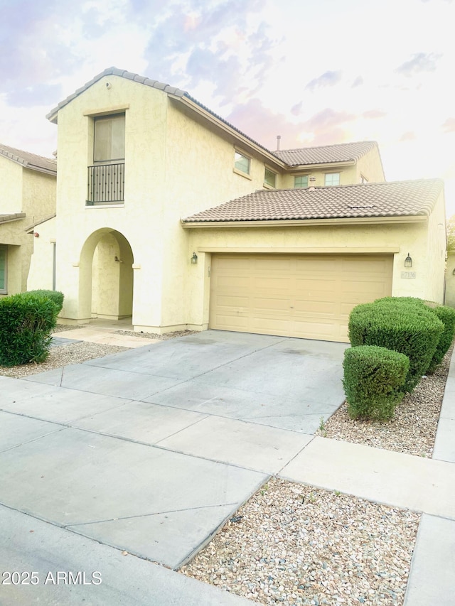 7136 N 73rd Dr, Glendale, AZ 85303 - view of front of house featuring concrete driveway, an attached garage, a tiled roof, and stucco siding