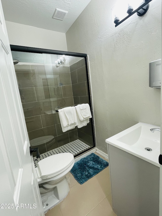 7136 N 73rd Dr, Glendale, AZ 85303 - bathroom with tile patterned flooring, visible vents, toilet, a stall shower, and a textured wall
