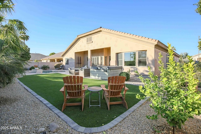 back of house with a hot tub, a patio, and a yard