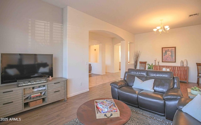 living room with a notable chandelier and light hardwood / wood-style floors