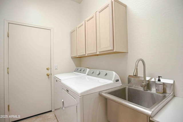 clothes washing area with light tile patterned flooring, cabinets, sink, and washing machine and dryer