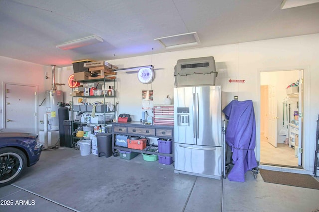 garage with water heater and stainless steel refrigerator with ice dispenser