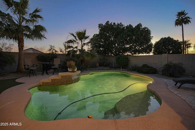 pool at dusk with a patio area