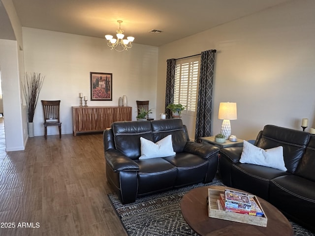 living room with dark hardwood / wood-style floors and a chandelier