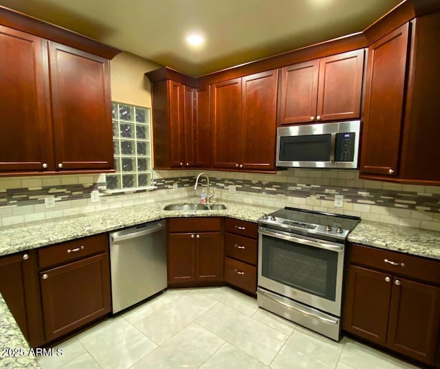 kitchen with a sink, stainless steel appliances, backsplash, and dark brown cabinets