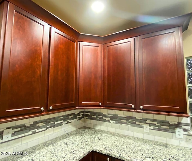 details with light stone counters, tasteful backsplash, and dark brown cabinets