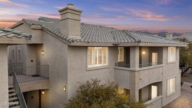 16013 S Desert Foothills Pkwy Unit 2120, Phoenix, AZ 85048 - view of home's exterior with stucco siding, a tiled roof, and a chimney