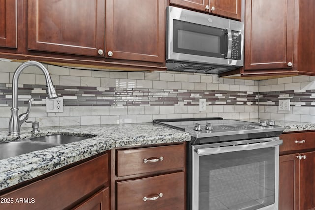 16013 S Desert Foothills Pkwy Unit 2120, Phoenix, AZ 85048 - kitchen featuring light stone counters, backsplash, stainless steel appliances, and a sink