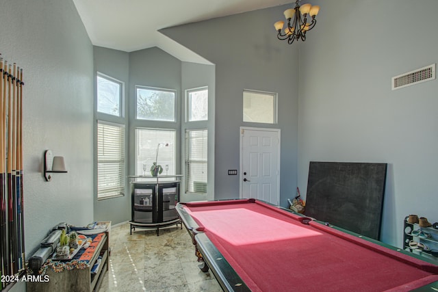 rec room featuring a towering ceiling, a chandelier, and pool table