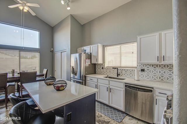 kitchen with ceiling fan, sink, high vaulted ceiling, white cabinets, and appliances with stainless steel finishes