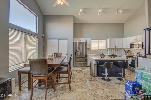 dining space featuring ceiling fan and high vaulted ceiling