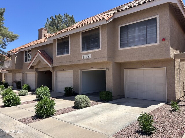 1633 E Lakeside Dr Unit 38, Gilbert, AZ 85234 - multi unit property featuring stucco siding, a tiled roof, a chimney, driveway, and an attached garage