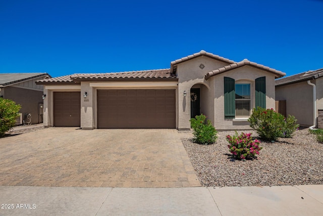 40470 W Agave Rd, Maricopa, AZ 85138 - mediterranean / spanish-style house featuring an attached garage, decorative driveway, stucco siding, and a tile roof