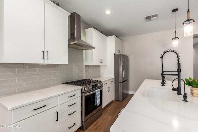 40470 W Agave Rd, Maricopa, AZ 85138 - kitchen featuring stainless steel appliances, wall chimney exhaust hood, a sink, decorative backsplash, and white cabinets