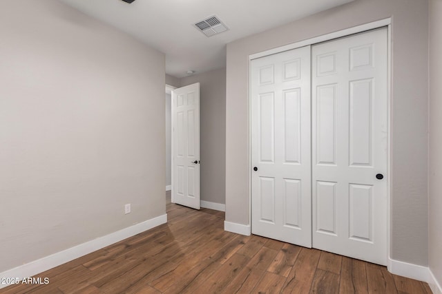 40470 W Agave Rd, Maricopa, AZ 85138 - unfurnished bedroom featuring baseboards, wood finished floors, and a closet