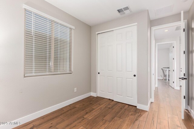 40470 W Agave Rd, Maricopa, AZ 85138 - unfurnished bedroom featuring wood-type flooring, a closet, baseboards, and recessed lighting