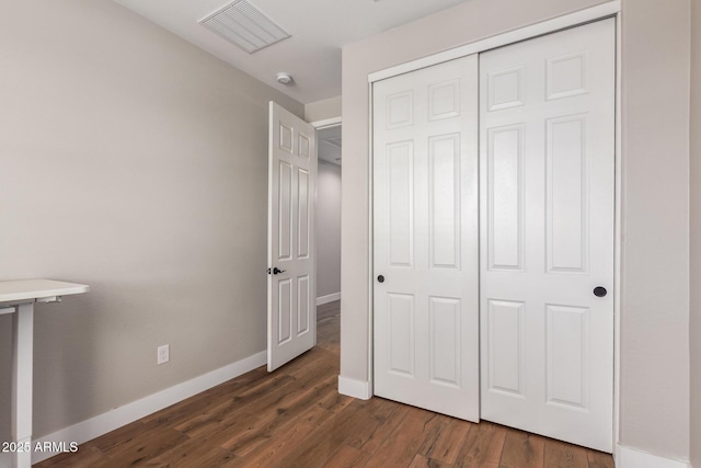 40470 W Agave Rd, Maricopa, AZ 85138 - unfurnished bedroom with dark wood finished floors, baseboards, and a closet