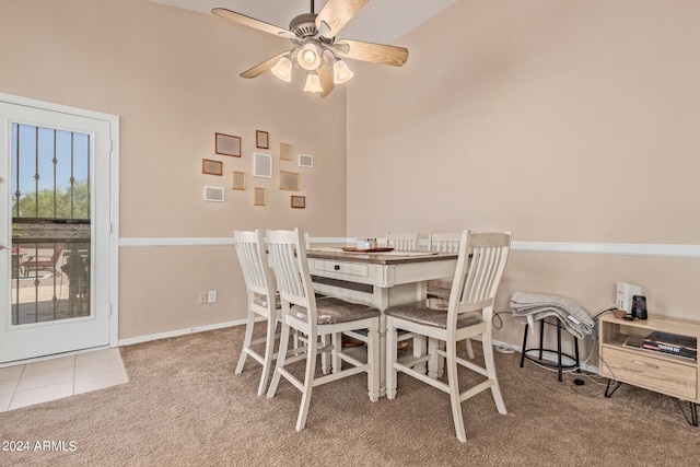 dining space featuring a towering ceiling, ceiling fan, and carpet floors