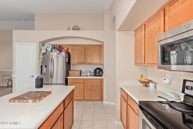 kitchen featuring stainless steel appliances and light tile flooring