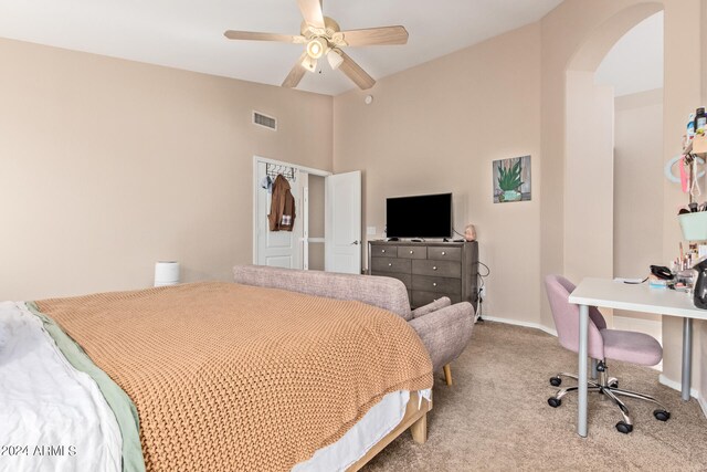 carpeted bedroom with ceiling fan and a high ceiling