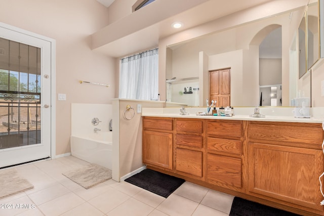 bathroom featuring double vanity, tile floors, and a tub