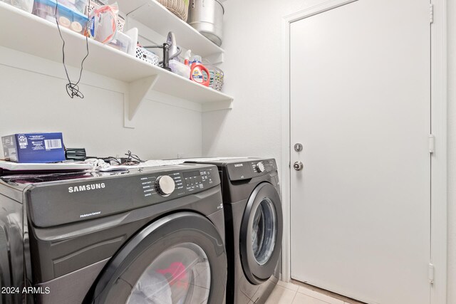 washroom with light tile floors and washer and dryer