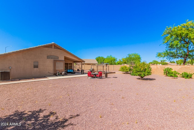 view of yard with central AC and a patio