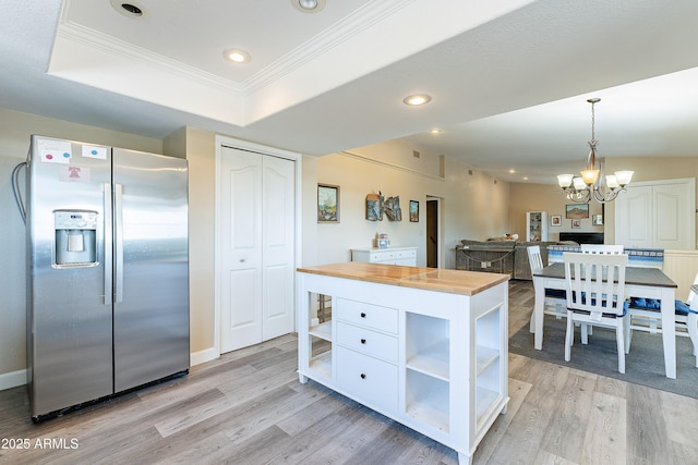 kitchen with stainless steel fridge, butcher block counters, light wood-style flooring, a tray ceiling, and open shelves